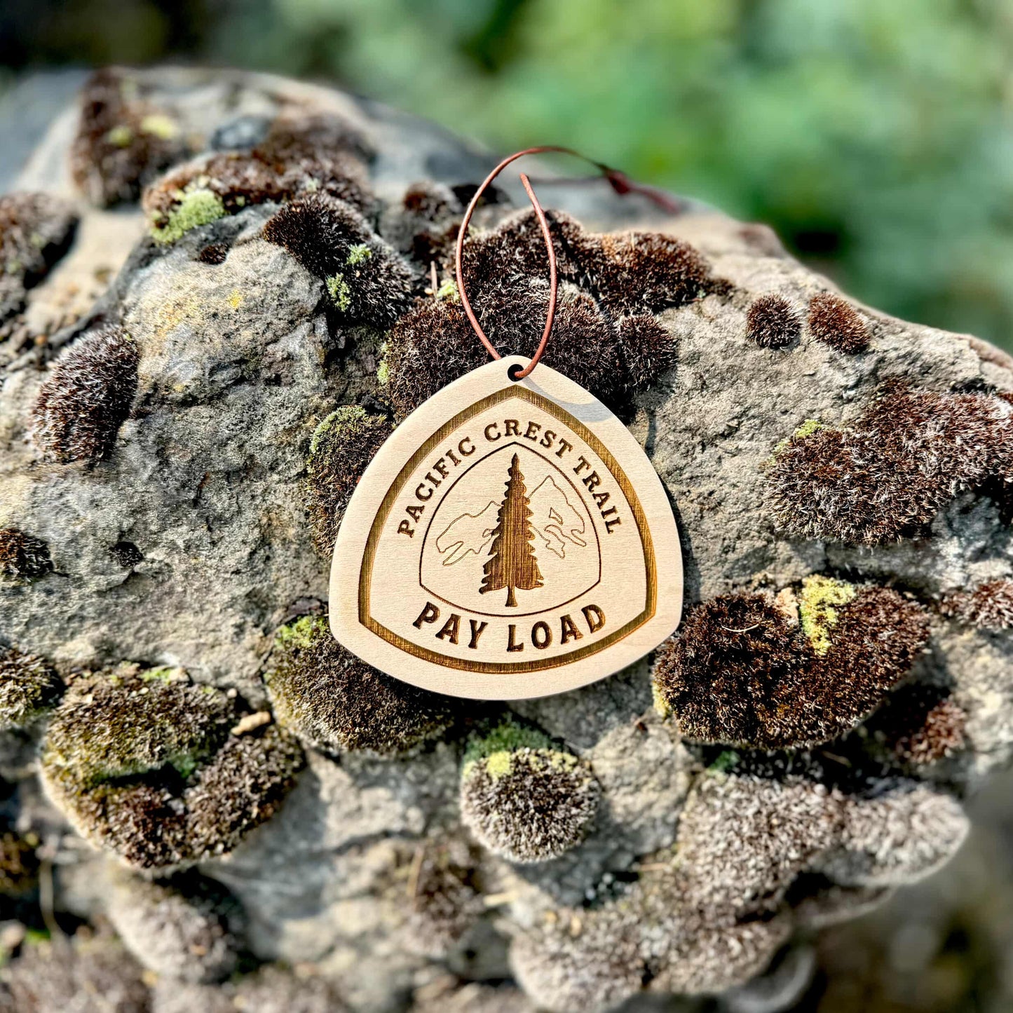 Personalized Pacific Crest Trail wooden name tag with custom engraving, Pacific Crest Trail custom backpack tag for thru-hikers, Custom engraved Pacific Crest Trail wooden tag photographed on hiking gear, Eco-friendly Pacific Crest Trail personalized tag gift for hikers, Pacific Crest Trail custom wooden ornament with engraved trail name, Handmade Pacific Crest Trail trail name tag made from reclaimed wood, Laser engraved Pacific Crest Trail backpack tag with trail name