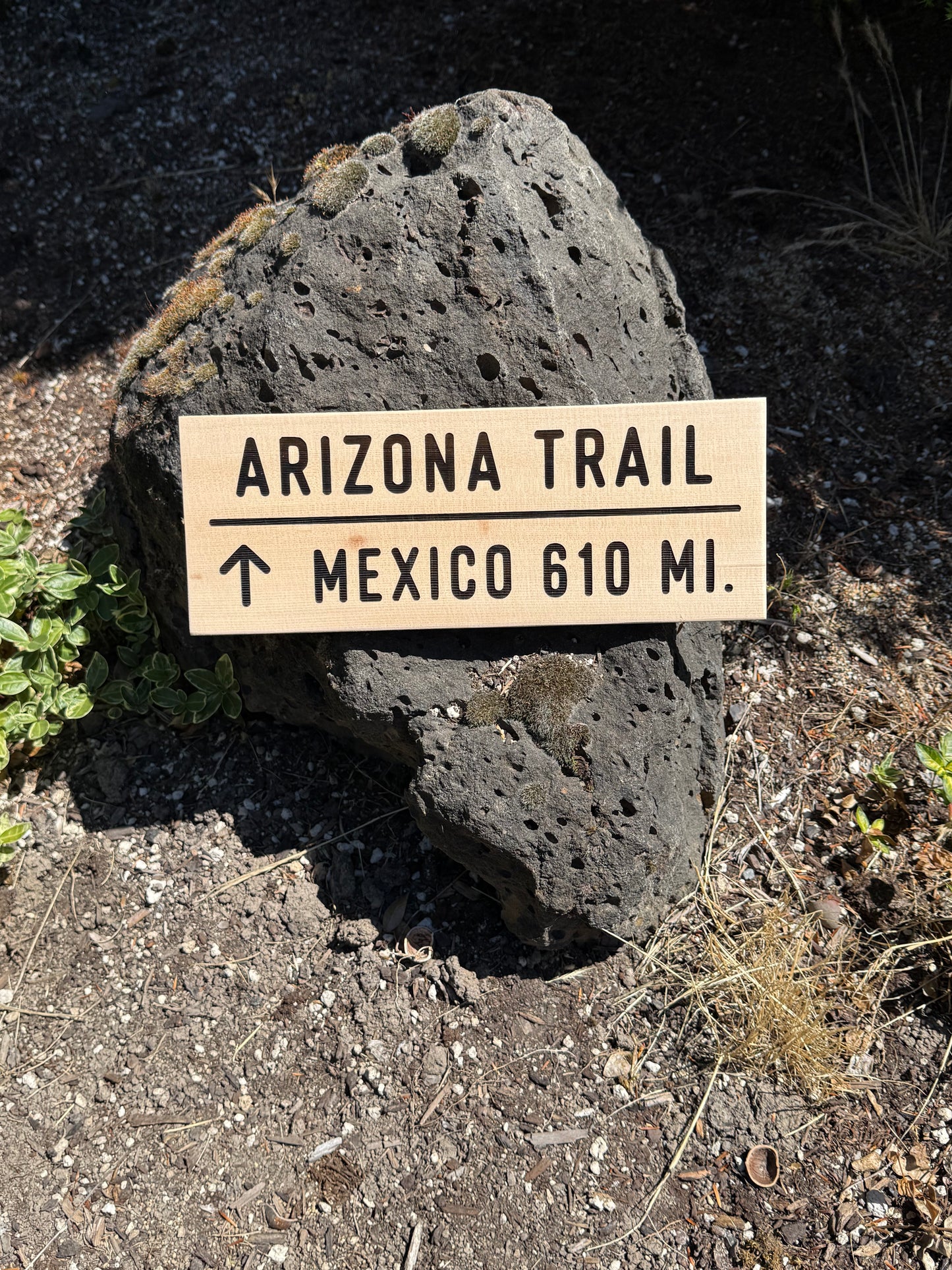 Sign indicating the distance to the Arizona Trail in Mexico on a rock