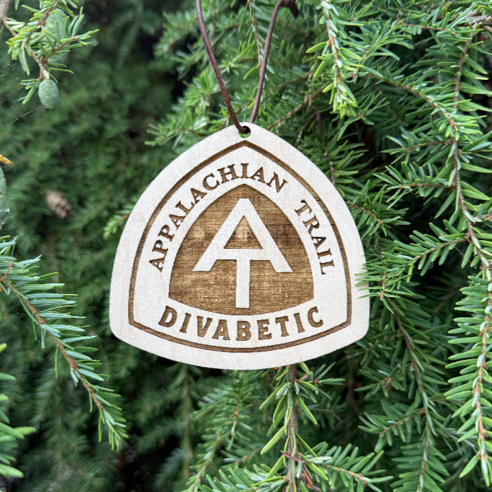Engraved Appalachian Trail wooden hangtag with the AT logo displayed against evergreen foliage
