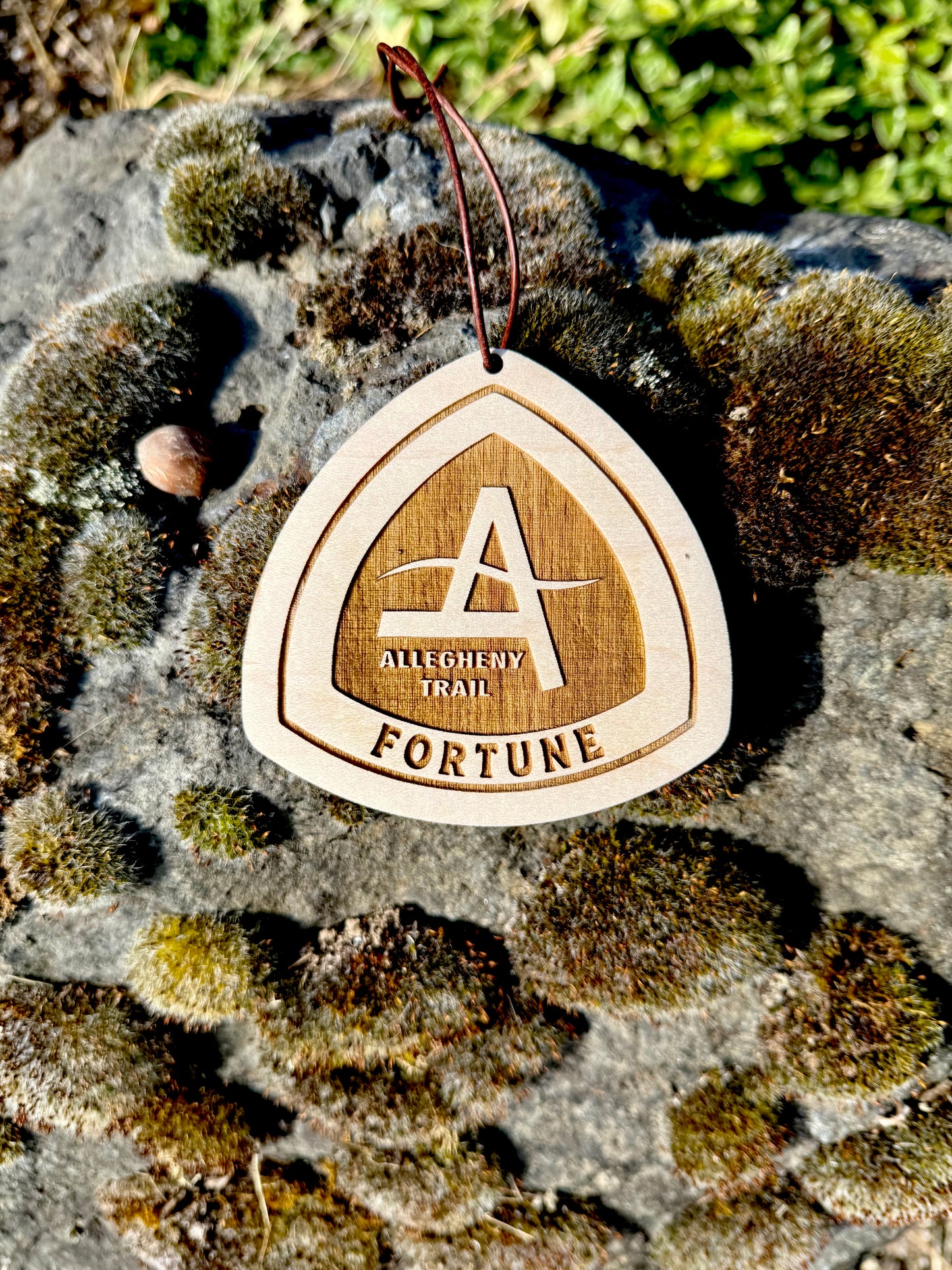 Close-up of a laser engraved Allegheny Trail personalized wooden name tag featuring a custom trail name. Handmade ultralight backpack accessory for long-distance hikers.