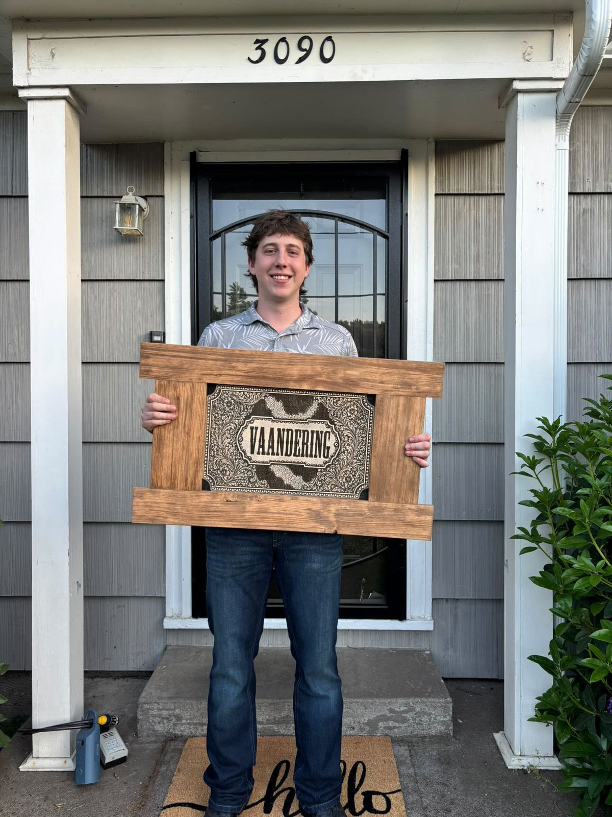 Customer holding a handcrafted wood sign, a personalized Realtor closing gift for a new home
