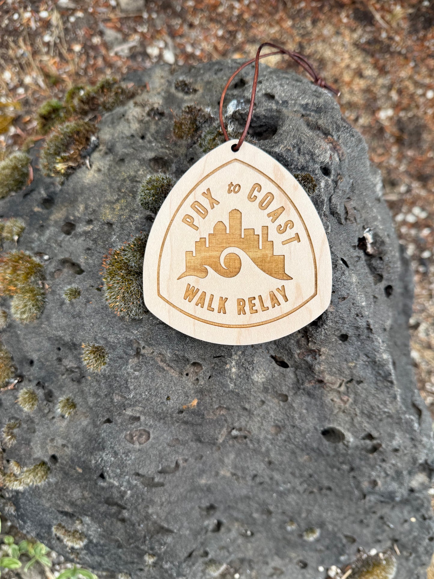 Close-up of a personalized PDX to Coast wooden hangtag featuring custom engraving, skyline artwork, and premium maple wood.