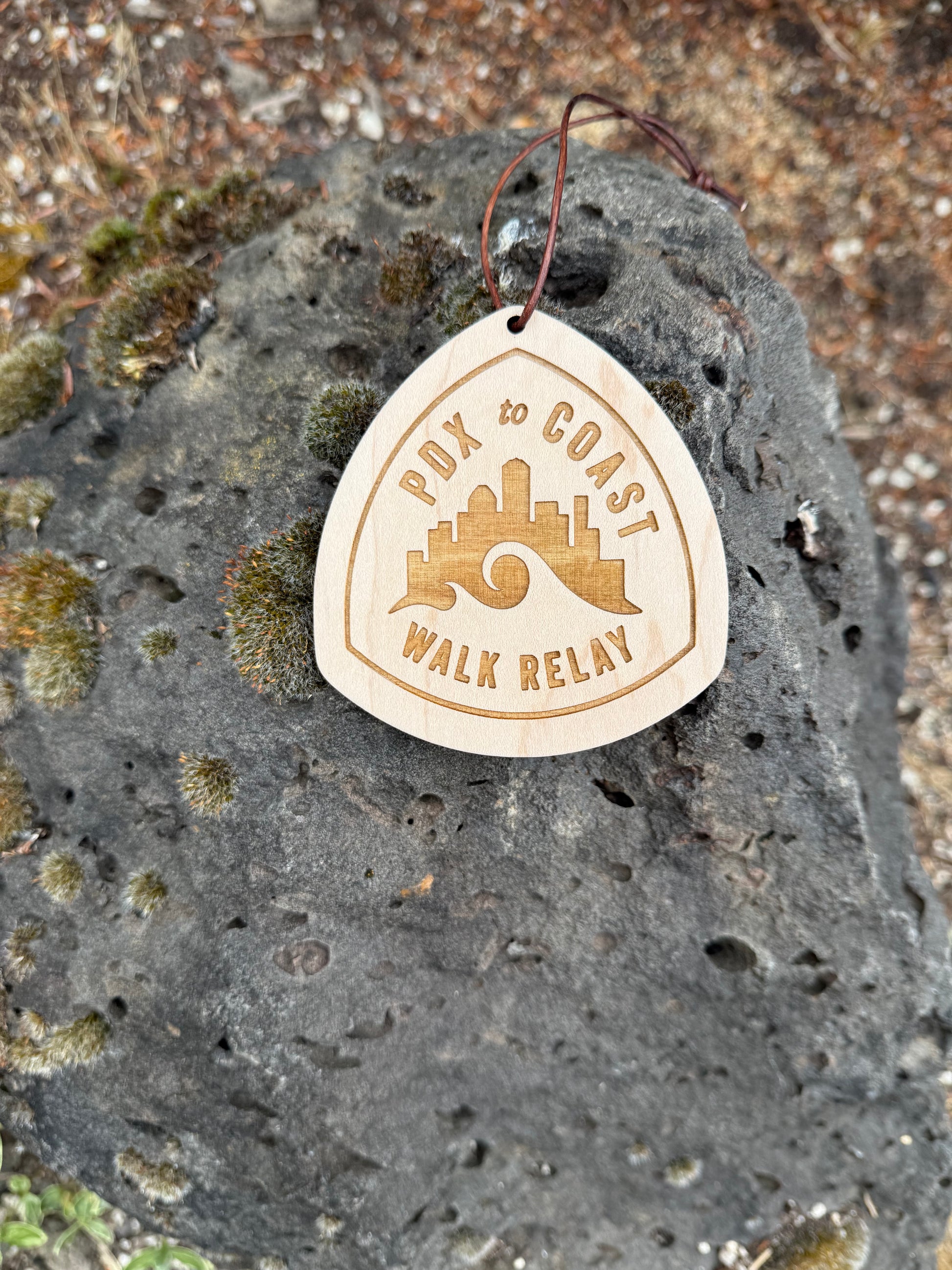 Close-up of a personalized PDX to Coast wooden hangtag featuring custom engraving, skyline artwork, and premium maple wood.