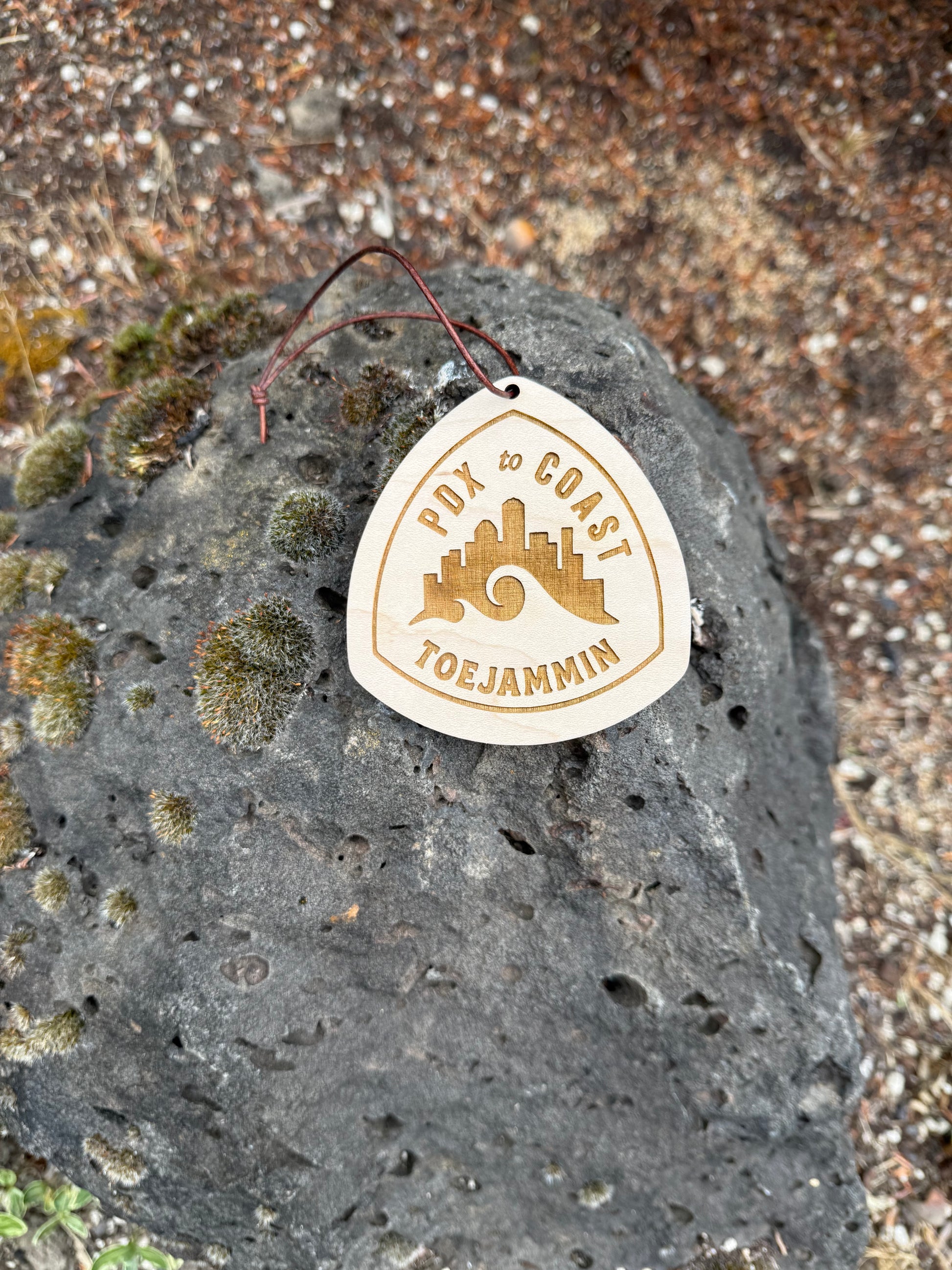 Personalized Portland to Coast hangtag hanging from a vehicle rearview mirror during the relay, perfect as a keepsake or van decoration.